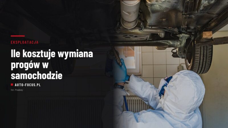 mechanik w kombinezonie natryskuje środek antykorozyjny na spód podniesionego samochodu
