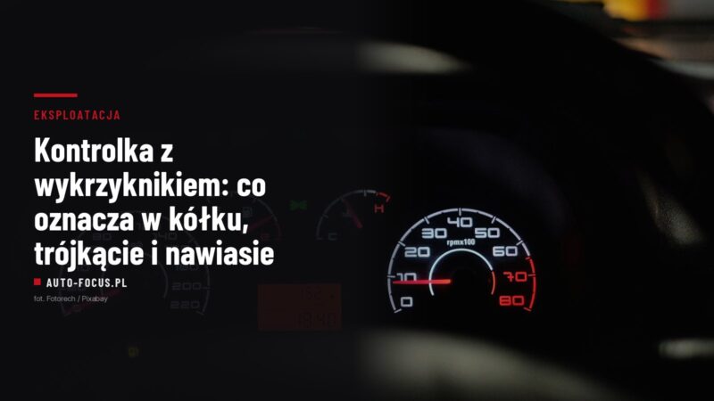 Podświetlone zegary samochodu nocą, w dolnej części tarczy pali się żółta kontrolka