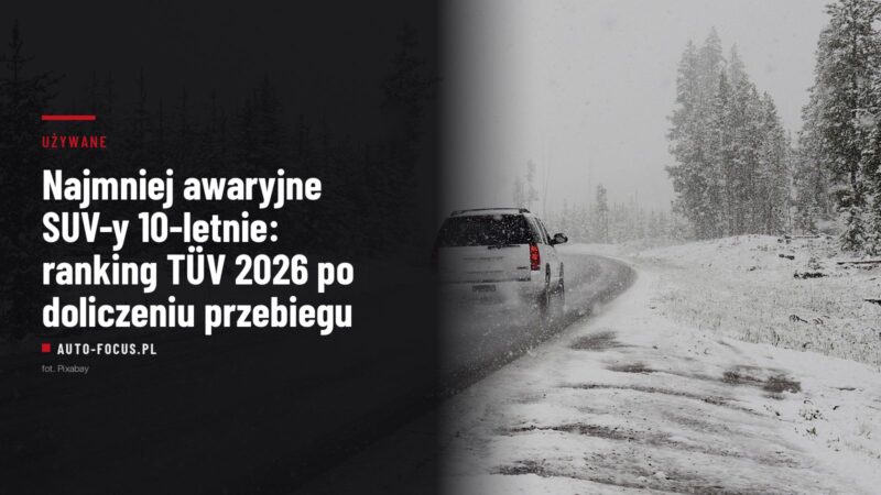 Biały SUV odjeżdżający zaśnieżoną leśną drogą podczas opadów śniegu