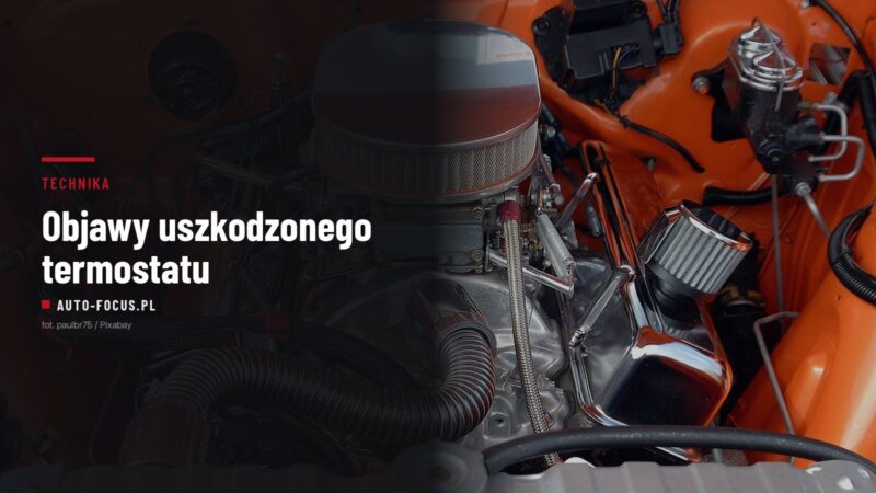 Komora silnika samochodu z widoczną chłodnicą, korkiem wlewu płynu i przewodami układu chłodzenia