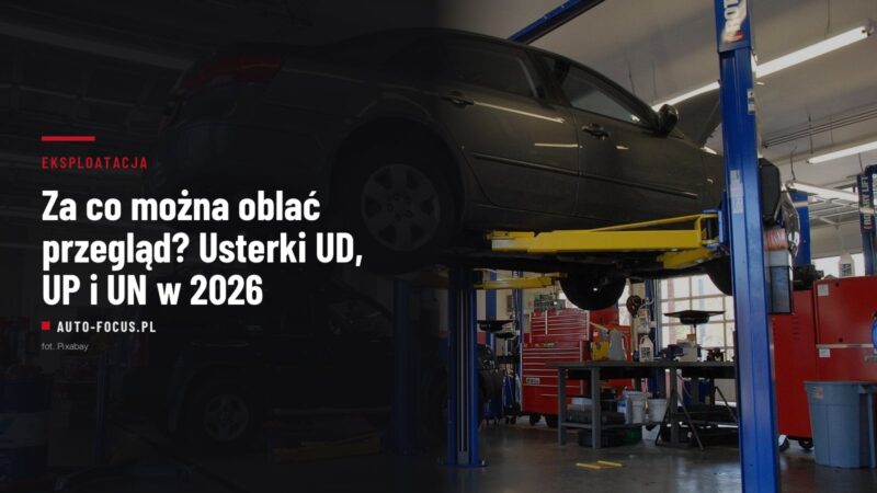 Samochód osobowy uniesiony na podnośniku dwukolumnowym w warsztacie